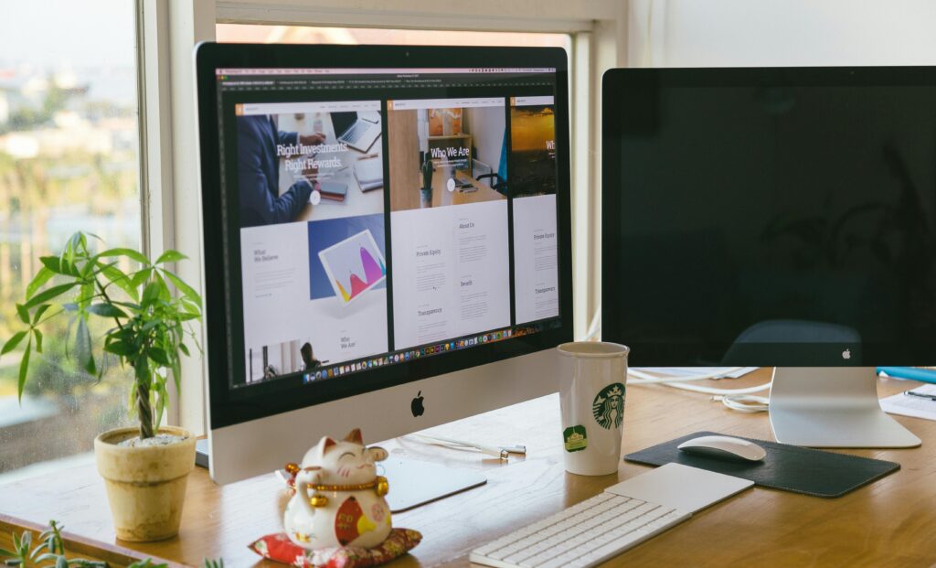 A bright workspace featuring an iMac, plant, and decor in a daylight setting.