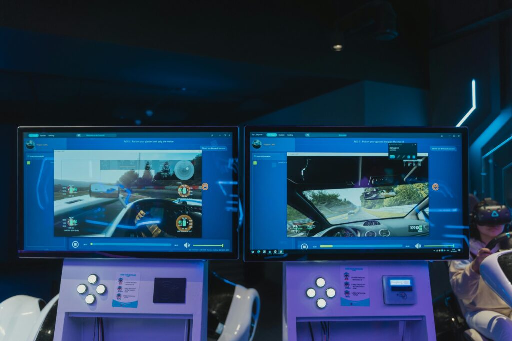 Immersive virtual reality gaming experience with dual screens and VR headsets, featuring driving simulations.