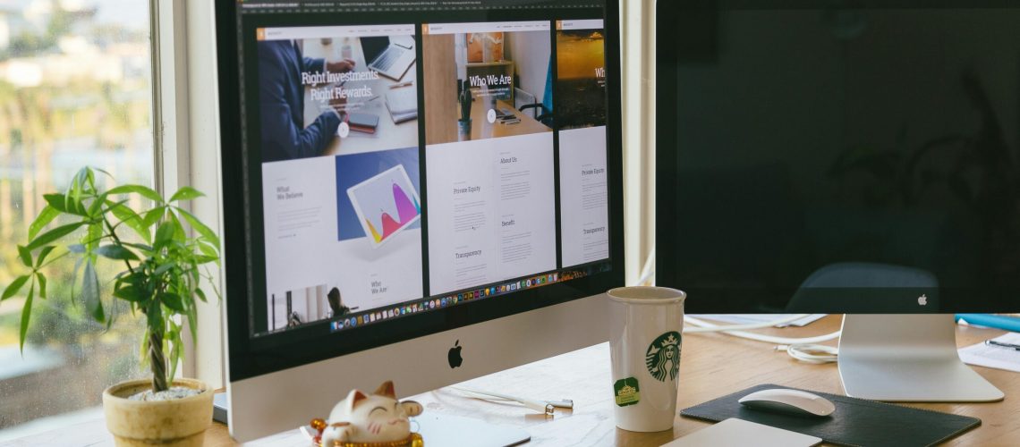 A bright workspace featuring an iMac, plant, and decor in a daylight setting.